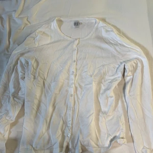 Vit cardigan med knappar - Säljer denna vita cardigan med knappar. Skönt och tunt material. Storlek XL men passar som en M.