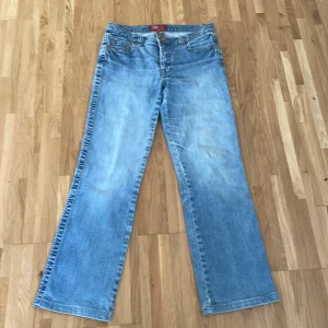 Blå jeans från Flash - Snygga blå jeans från Flash med klassisk femficksdesign och dekorativa sömmar på bakfickorna. De har en rak passform och är perfekta för en avslappnad stil. Märket Flash står för enkelhet och komfort. Storlek 40 men passar mig som har storlek 36 om jag viker ner dom❤️
