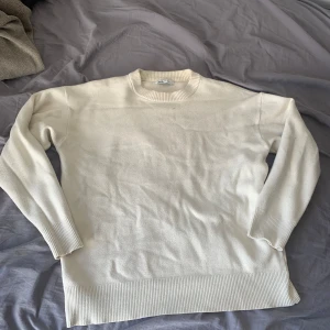 Vit tröja från Zara - Säljer en stilren vit tröja från Zara. Tröjan har en klassisk design med långa ärmar och ribbade muddar vid ärmslut och nederkant. Perfekt för en minimalistisk look.