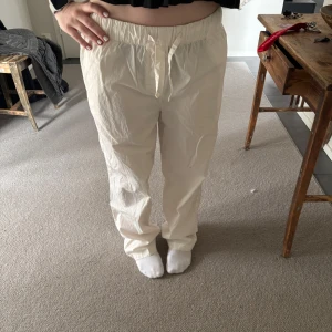 Boii Studio byxor - Säljer ett par bekväma byxor med elastisk midja och dragsko. Perfekta för en avslappnad stil. Byxorna har en loose passform och är tillverkade i ett lätt material.