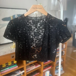 Svart spetsbolero från Vila - Snygg svart bolerotopp i spets från Vila. Perfekt för att lägga till en elegant touch till din outfit. Den har korta ärmar och är tillverkad i ett stretchigt material för en bekväm passform.