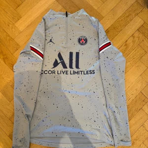 Grå långärmad zip tröja från Jordan x PSG - Säljer en grå halfzip från Jordan i samarbete med PSG. Tröjan är i väldigt bra skick då jag knappt använt den, skulle säga 9/10. Storlek S. Priset går att diskutera vid snabb affär💰. Vid frågor eller funderingar hör av er!