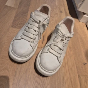 Alexander McQueen sneaker - Snygga vita sneakers med snörning och rund tå. Skorna har en stilren design med en mjuk häl i mocka för extra komfort. Perfekta för en avslappnad stil.