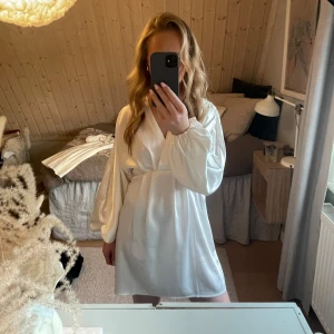 Vit satinklänning - Jättefin vit satinklänning från Gina Tricot. Endast använd en gång. Har en liten maska fram men absolut inget man tänker på!💗