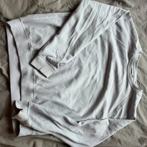 Blå sweatshirt - Säljer en klassisk blå sweatshirt med rund hals och långa ärmar. Perfekt för en avslappnad stil. Den har ribbade muddar vid ärmslut och nederkant för extra komfort.