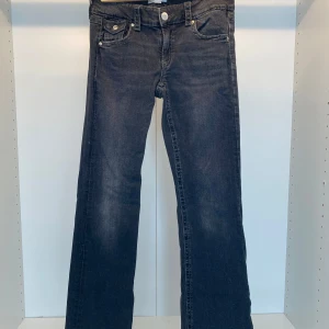 Lågmidjade bootcut jenas - Svarta coola bootcut jeans som är Lågmidjade! Är i fint skick men använda. Har silver knappar på framsidan men på baksidan på fickorna också. Är i storlek 170 men passar Xs-S