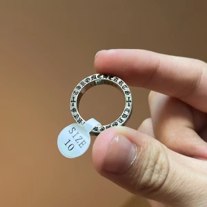 Chrome Hearts Silverring  - Snygg Chrome Hearts silverring med ingraverad text och stjärndetaljer runt om. Perfekt för att ge en unik touch till din stil. Storlek 10.