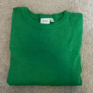 Grön tröja från Vila - Säljer en snygg grön tröja från Vila. Tröjan har en rund halsringning och långa ärmar. Perfekt för en färgglad touch i garderoben.