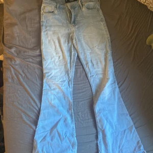 Ljusblå jeans från Hollister - Säljer ett par ljusblå high-rise flare jeans från Hollister. De har en klassisk stretch och är perfekta för en avslappnad stil. Jeansen har en snygg flare passform som ger en retro känsla.