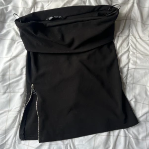 Svart axellös topp med dragkedjor - Snygg svart topp med två dragkedjor framtill som ger en cool look. Från zara i storlek S💕