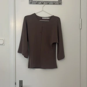 Brun blus från InWear - Elegant brun blus från InWear med trekvartsärmar och en stilren design. Perfekt för en chic och sofistikerad look. Passar bra till både jeans och kjol.