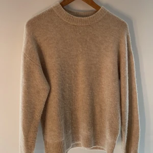 Gosig Beige stickad tröja - Säljer en mysig beige stickad tröja med rund hals och långa ärmar. Tröjan har ribbade muddar vid ärmslut och nederkant, perfekt för kyliga dagar. Passar både till vardags och när du vill mysa hemma. 🧶storleken sitter som en s💕