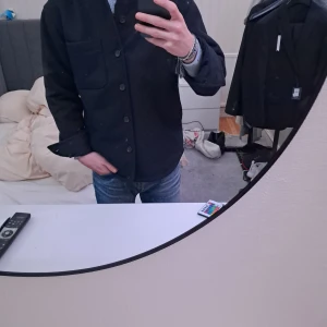 Overshirt med knappar - Snygg marinblå overshirt med knappar framtill och två stora fickor. Perfekt för en stilren look. Passar bra till både jeans och mer formella byxor.