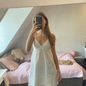 Vit ärmlös klänning med spetsdetaljer - Säljer en söt vit klänning med v-ringning och spetsdetaljer. Klänningen är ärmlös med smala axelband som går att justera. Super fin rygg och perfekt till skolavslutning, student, sommardagar m.m.!💓