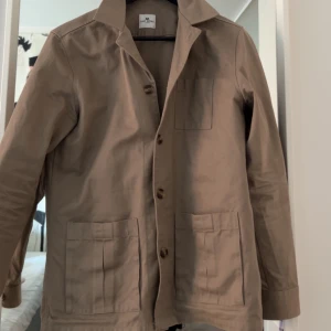 Beige overshirt från John Henric - Säljer en as snygg overshirt från John Henric. Jag är rätt säker på att man inte kan köpa den längre vilket gör den ännu mer exklusiv. Jag köpte den för runt 2 år sedan för 1200kr, säljer den för 799 men kan gå ner om vi gör en snabb affär!