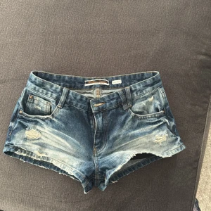 Blå jeansshorts från The Denim Collection - Snygga blå jeansshorts med slitna detaljer och fransar från The Denim Collection. Priset går att diskuteras 