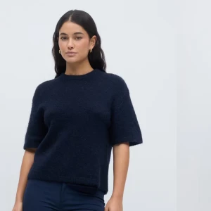 Mörkblå tröja med korta ärmar - Snygg mörkblå tröja med korta ärmar och rund hals. Perfekt för en stilren look. Tröjan har en mjuk och bekväm passform.