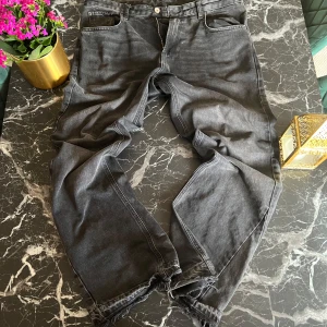 Svarta jeans från Zara - Snygga svart jeans från Zara i en klassisk straight fit. De har en normal passform med fem fickor och knappgylf. Perfekta för en avslappnad stil.