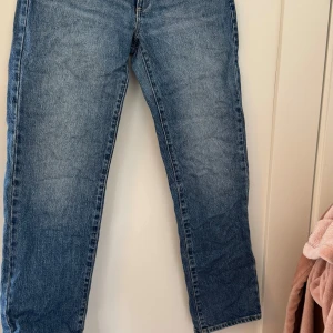 Blå jeans A '99 Low Straight - Säljer ett par klassiska blå jeans med en straight passform och låg midja. De har en snygg tvätt och är gjorda i ett slitstarkt denimtyg.