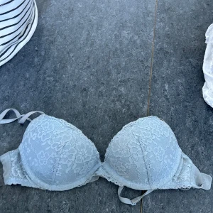 Ljusblå spets-bh från H&M - Säljer en ljusblå bh från H&M med vacker spetsdetalj. Den har vadderade kupor och justerbara axelband för bästa passform. Perfekt för att känna sig både bekväm och fin.