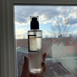COSRX Advanced Snail 96 Mucin Power Essence - En flaska med COSRX Advanced Snail 96 Mucin Power Essence. Produkten är känd för sin återfuktande och reparerande egenskaper, perfekt för att ge huden en fräsch och strålande look. Flaskan har en praktisk pump för enkel applicering.