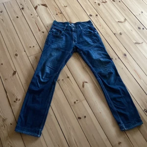 Blå jeans från Grant - Säljer ett par klassiska blå jeans från Grant, modell 989. De har en rak passform och är tillverkade i slitstarkt denim. Perfekta för en avslappnad stil.