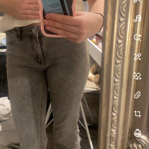 Grå jeansbyxor - Lågmidjade grå jeansbyxor med en klassisk femficksdesign. De har en knapp och dragkedja framtill och är i en stilren grå färg som passar till det mesta. Perfekta för en avslappnad look.