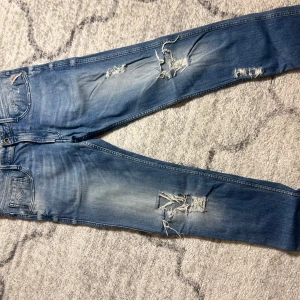 Replay Anbass - Säljer ett par Replay jeans med slitningar och hål för en trendig look. Jeansen har en klassisk fem ficks design . Perfekta för en  så kallad grisch / Stockholm stilen