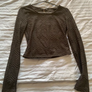 Brun stickad topp från XXI - Säljer en snygg svart stickad topp från XXI med ett zigzag-mönster. 