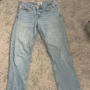 Ljusblå lågmidjade jeans XXS - Säljer ett par lågmidjade ljusblå jeans. De har en rak passform och är perfekta för en avslappnad stil. Jeansen har fem fickor och en knappgylf. Från lager 157 i storlek XXS