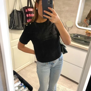 Svart topp med silver detaljer - En svart tröja med fina silver knappar, helt oanvänd 