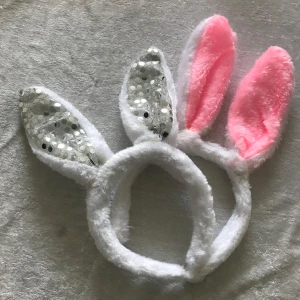Diadem med kaninöron - Sött diadem med kaninöron i vitt och rosa. Ena örat är täckt med glittriga paljetter och det andra är i mjuk rosa plysch. Perfekt för en rolig och lekfull look! Ny 