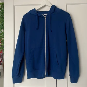 Blå hoodie från Primark - Säljer en snygg blå hoodie från Primark. Den har en dragkedja framtill och en praktisk huva med dragsko. Perfekt för en avslappnad stil. 💙