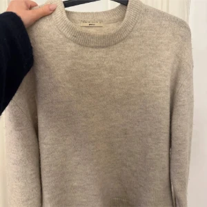 Beige stickad tröja  - Säljer en mysig beige stickad tröja från Gina Tricot i premiumkvalitet. Tröjan har en rund halsringning och långa ärmar, perfekt för kyliga dagar. Den är i storlek XS. pyttelitet hål i armhålan men inget som syns vid användning därav priset