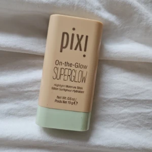 Pixi On-the-Glow Superglow highlighter - Glow up med Pixi On-the-Glow Superglow! En highlighter i smidig stickform som ger en snygg, skimrande finish. Färgen är champagneguldig och formulan är krämig och återfuktande. Perfekt att svepa över kindben, näsrygg eller där du vill ha extra lyster.
