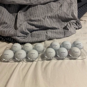 titleist golfbollar - Bilderna visar sex stycken Titleist Pro V1 golfbollar i en plastförpackning. Bollarna är vita och har märkningar med siffror och logotyp. Perfekt för dig som vill ta ditt golfspel till nästa nivå med kvalitetsbollar. SKRIV OM NI HAR NÅGRA FRÅGOR ELLER OM DU VILL HA MER ÄN VARA DET SOM ÄR MER PÅ BILD!!!