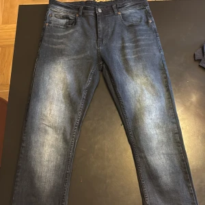 Blå skinny jeans från Crone - Snygga blå jeans från Crone med skinny passform och klassisk femficksdesign. Jeansen har en tvättad look med ljusare partier framtill och baktill, samt detaljerade sömmar. Perfekta för dig som gillar en modern och stilren vibe.