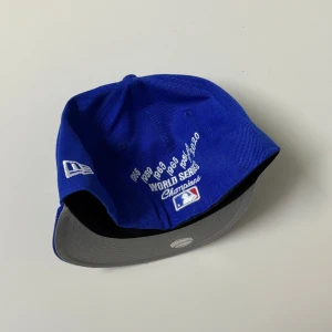New era 59fifty keps - Snygg blå LA Dodgers keps från New Era 59FIFTY-serien. Framsidan har broderad LA-logga, krona, ros och text. Undersidan av skärmen är grå. Broderad text på sidan och baksidan med World Series Champions-detaljer. 100% polyester.