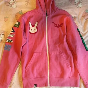 Overwatch hoodie - Äkta Overwatch merch (designed by jinx) Har några fläckar på ärmsluten. Står stl S men är väldigt stor på mig som använder xs-d, skulle säga snarare S-L beroende på vilken passform du vill ha.