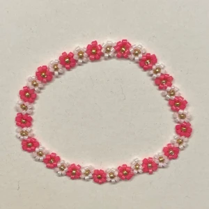 Pärlarmband med blommor i rosa - Hemgjort armband gjort av små pärlor i rosa och guld. Perfekt accessoar för att ge din outfit en söt och färgglad touch.                          Kan såklart göras i andra färger och storlekar!Obs! -guldpärlorna kan tappa sin färg om de tvättas mycket i vatten💞💞