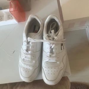 Vita sneakers från Tommy Jeans - Snygga vita sneakers från Tommy Jeans med klassisk låg profil och rund tå. Skorna har perforerade detaljer framtill, snörning och den ikoniska Tommy Jeans-loggan på sidan. Ny pris 2000kr. Andvänt bara 2 gånger 
