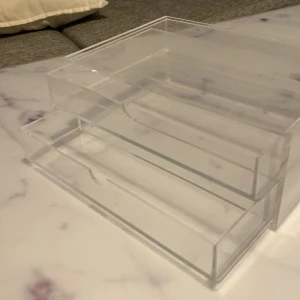 Transparent sminkförvaring i akryl - Snygg och stilren sminkförvaring i genomskinlig akryl med två utdragbara lådor. Perfekt för att organisera sminkborstar, läppstift eller ögonskuggor på sminkbordet. Enkel att matcha med alla inredningsstilar och superpraktisk för att hålla ordning bland dina favoriter.