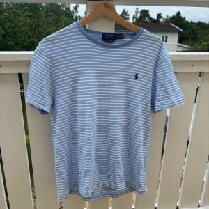 Ralph Lauren t-shirt - Snygg blå och vit randig t-shirt från Polo Ralph Lauren i bomull. Klassisk passform med korta ärmar och rund hals. Hör av dig om du har några frågor! 