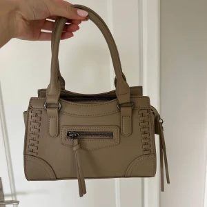 Handväska - Beige handväska i nyskick! Väskband tillkommer även.