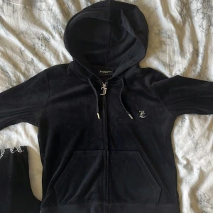 Svart velour set Juicy Couture M - Svart hoodie och byxor från Juicy Couture i mjuk velour med dragkedja och huva. Klassisk logga framtill och glittrande Juicy-text baktill. Perfekt för en chill och trendig look. Nypris ungefär 2000kr. Både hoodien och byxorna är i storlek M!🤍Går att köpa separat om det önskas men helst tillsammans🤗850kr för båda, 450 för bara hoodie/byxa. 