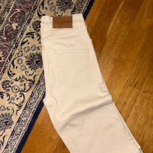 Ljusbeige raka jeans från Wera - Superfina jeans från Wera i storlek 34. Säljes pga för små. Liten fläck baktill som säkert försvinner i tvätten annars i knappt använt skick!