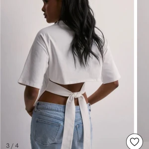 Vit topp med knyt från Nelly - Säljer en populär vit omlottopp från Nelly i storlek S. Toppen har knytband i midjan som ger en snygg och trendig siluett. Tillverkad i mjuk bomull och passar perfekt till jeans eller kjol för en clean look.