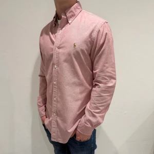 Rosa skjorta från Ralph Lauren - Rosa skjorta från Ralph lauren|| Storlek S ( Custom Fit) || skjortan är i mycket bra skick || mitt pris 499kr || modellen på bilden är 170cm och väger 60kg || tveka inte på att höra av dig vid frågor eller funderingar 