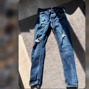Blå slitna jeans från Dsquared2 - Säljer ett par blå jeans från Dsquared2 med snygga slitningar och trasiga detaljer på benen. Den är storlek 30💙