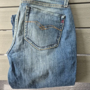 Replay jeans  - Snygga jeans från Replay i ljusblå tvättad denim. Klassisk femficksmodell med Replay-logga på bakfickan och kontrastsömmar. Jeansen har låg midja och smal passform hela vägen ner. 